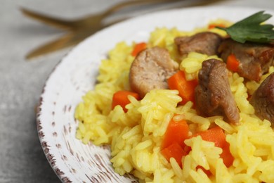 Photo of Delicious pilaf with meat on light grey table, closeup