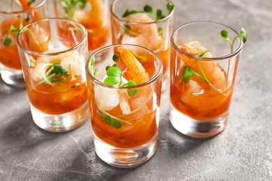 Photo of Delicious shrimp cocktail shots on grey table