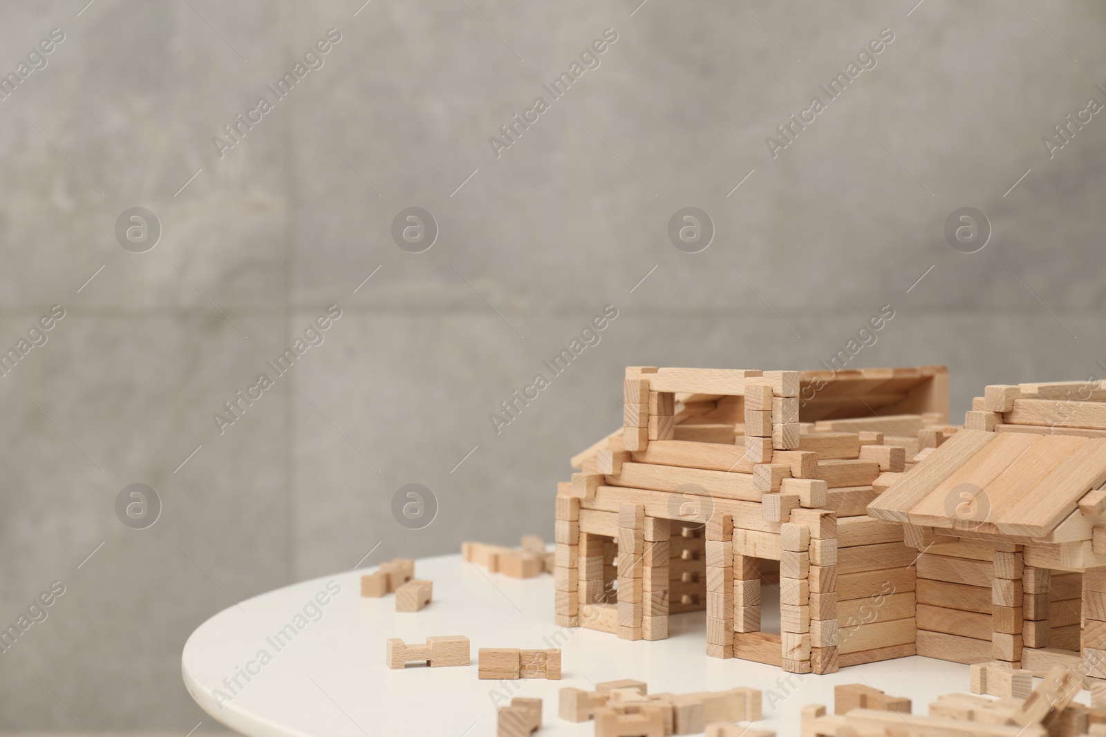 Photo of Wooden construction set on white table, space for text. Children's toy