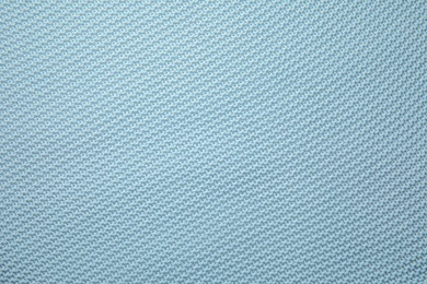 Photo of Soft light blue knitted plaid as background, top view