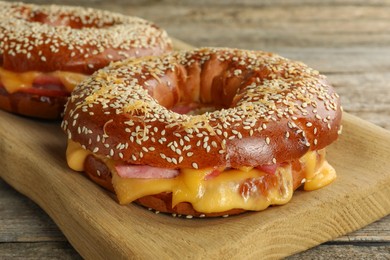 Photo of Delicious bagels with ham and cheese on table