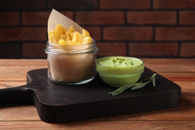 Photo of Serving board with french fries, guacamole dip and rosemary on wooden table