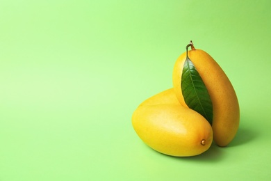 Photo of Fresh ripe mango fruits on color background. Space for text