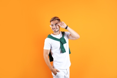 Photo of Young man with trendy hairstyle on color background