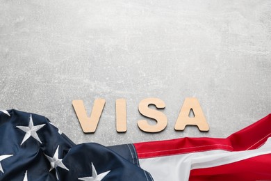 Photo of Word Visa and American flag on light grey table, flat lay. Space for text