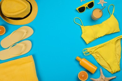 Flat lay composition with beach objects on light blue background, space for text