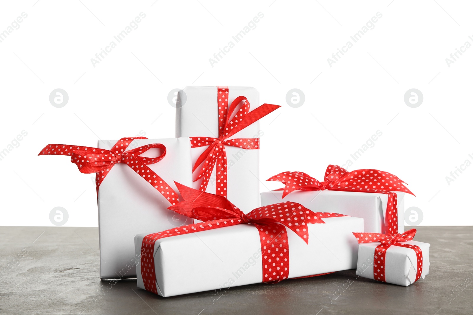 Photo of Many Christmas gifts on grey table against white background