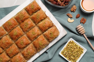 Delicious sweet baklava with ingredients on table, flat lay