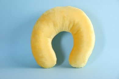 Photo of Yellow travel pillow on light blue background