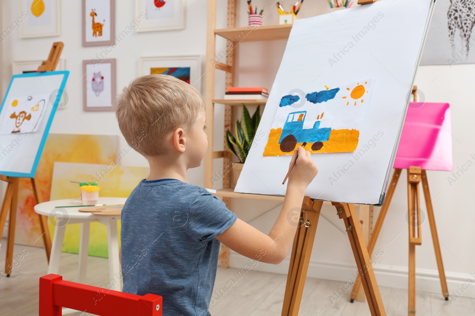 Photo of Cute little child painting during lesson in room