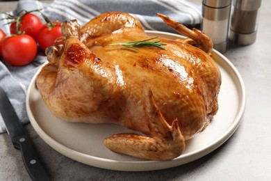 Photo of Tasty roasted chicken with rosemary on light grey table