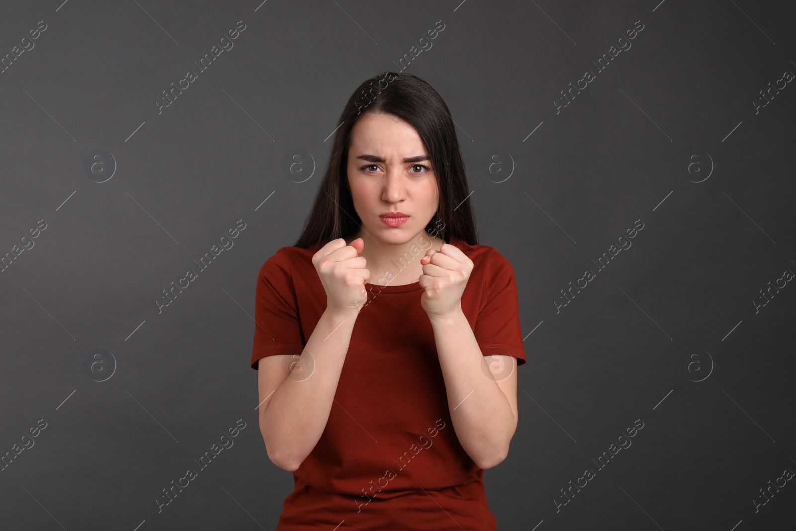 Photo of Portrait of emotional young woman on dark grey background. Personality concept