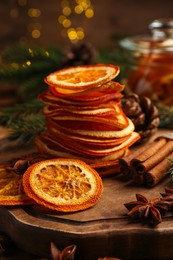 Photo of Dry orange slices, anise stars and cinnamon sticks on wooden board. Bokeh effect