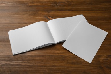 Sheet of paper and blank brochure on wooden table. Mockup for design
