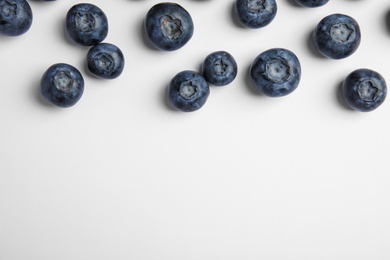 Photo of Tasty ripe blueberries on white background, flat lay