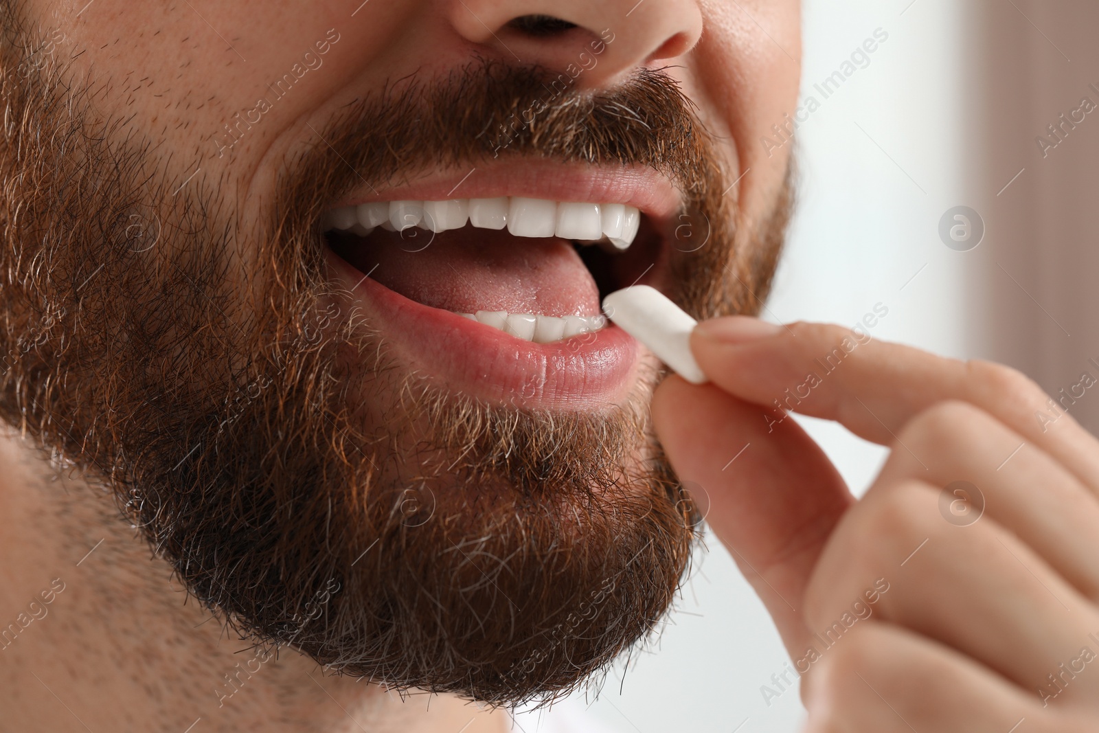 Photo of Man with chewing gum on blurred background, closeup