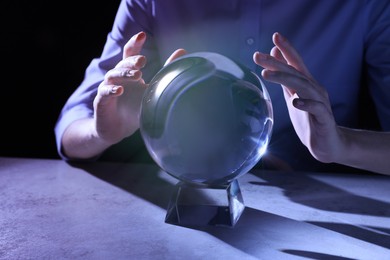 Photo of Businesswoman using ball to predict future at table, closeup