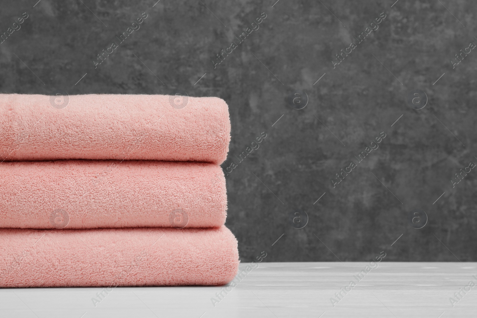 Photo of Stack of soft clean towels on table. Space for text