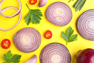 Photo of Flat lay composition with slices of onion and spices on yellow background