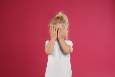 Cute little girl posing on pink background