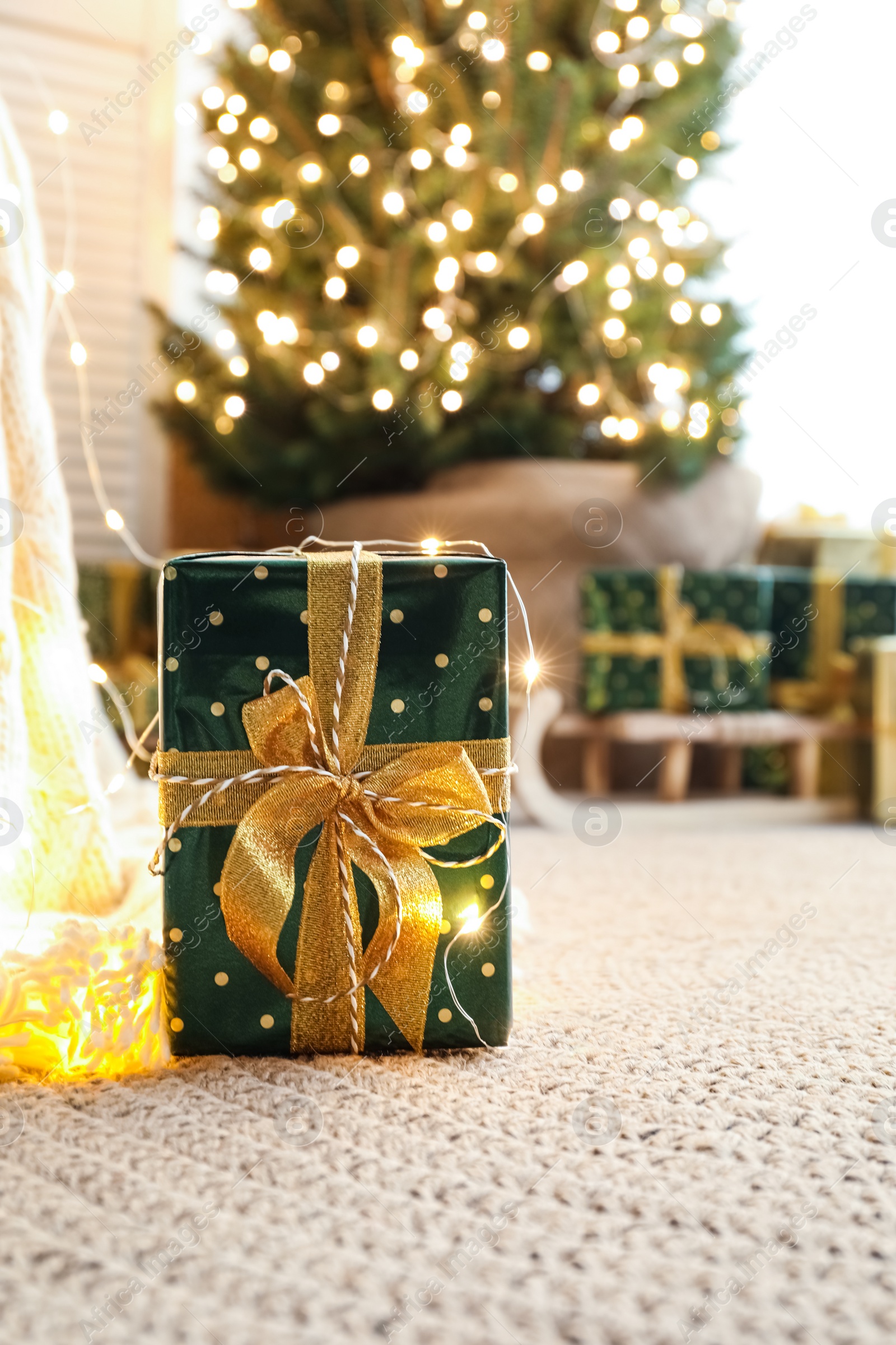 Photo of Beautiful Christmas gift and blurred pile of presents on background. Space for text