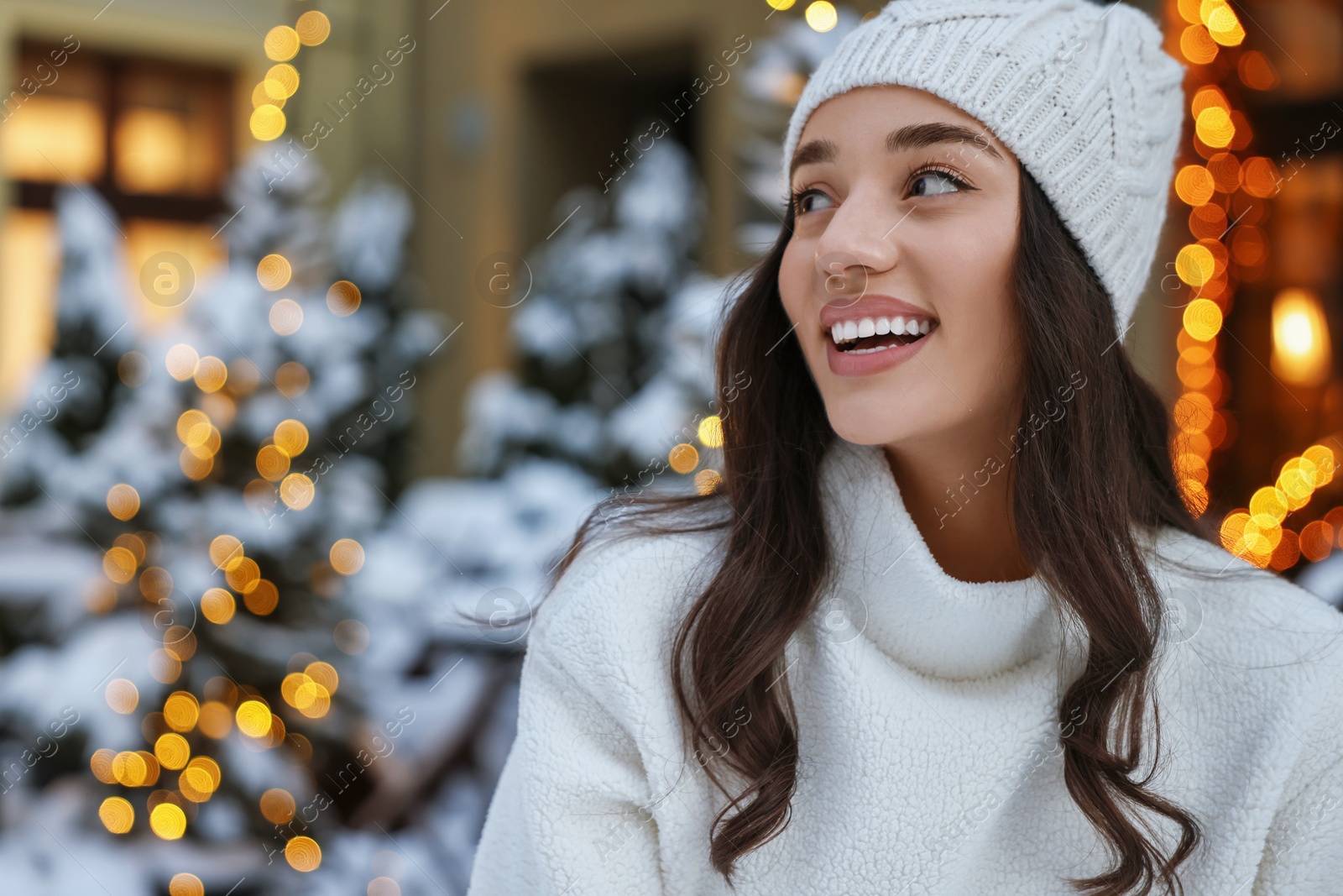 Photo of Portrait of happy woman on city street in winter. Space for text