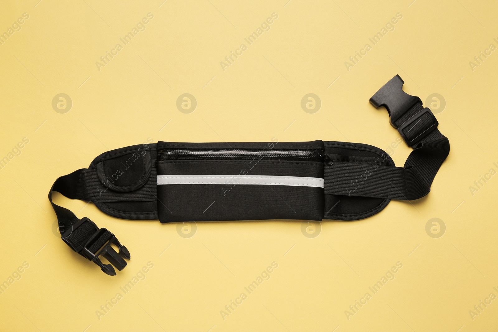 Photo of Stylish black waist bag on green background, top view