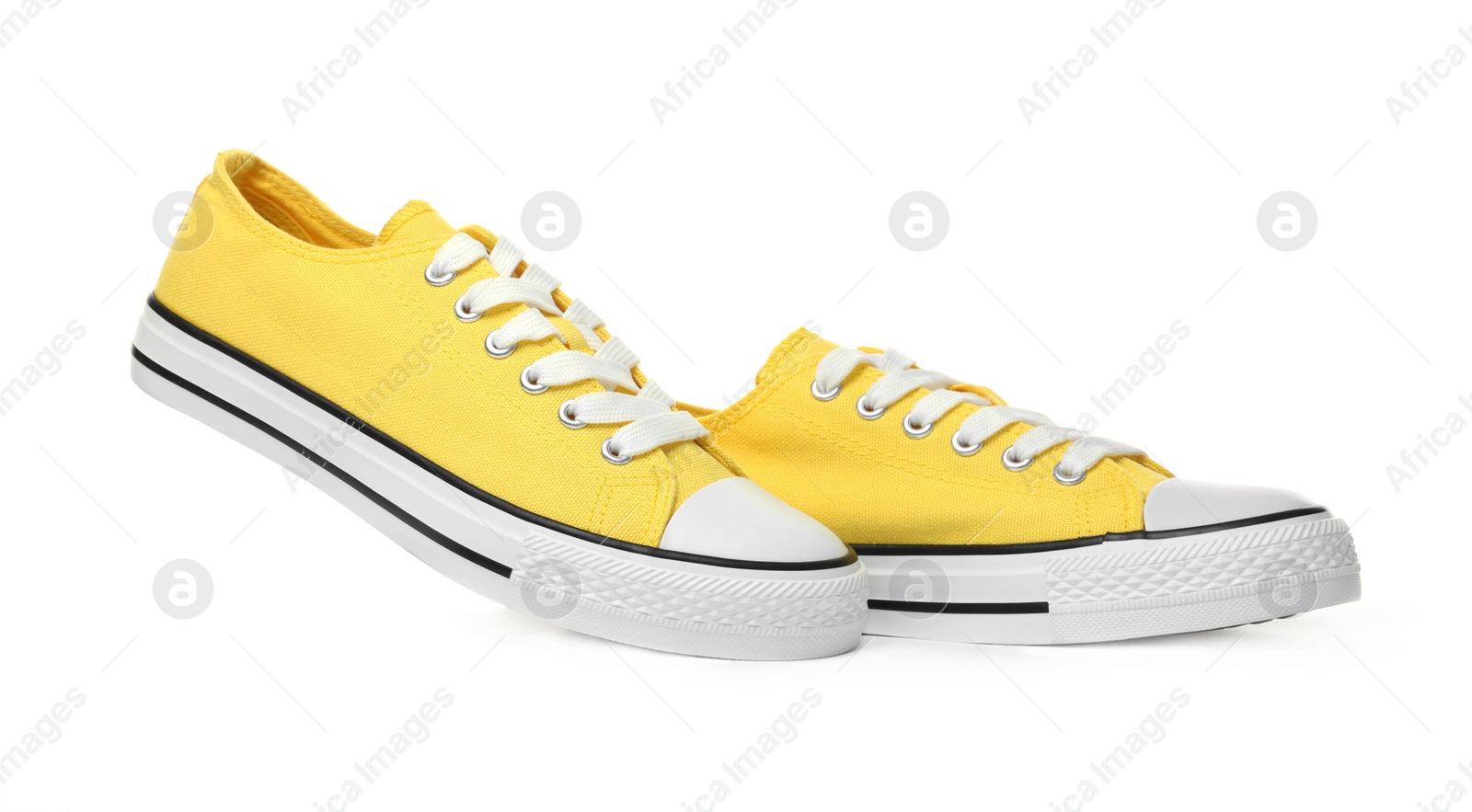 Photo of Pair of yellow classic old school sneakers on white background