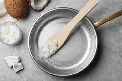 Photo of Flat lay composition with coconut oil and frying pan on grey marble table. Healthy cooking