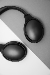 Photo of Modern wireless headphones on color background, top view