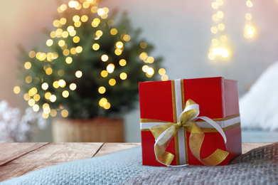 Image of Beautiful Christmas gift on wooden table against blurred background