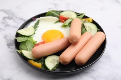 Photo of Delicious breakfast with boiled sausages and fried egg on white marble table, closeup