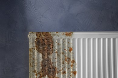 Image of Modern panel radiator affected by rust on grey background