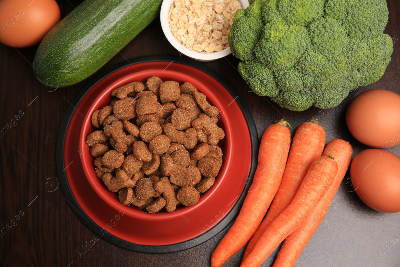 Photo of Dry pet food and products on wooden background, flat lay
