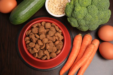 Dry pet food and products on wooden background, flat lay