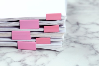 Photo of Stack of documents with binder clips on marble table, closeup