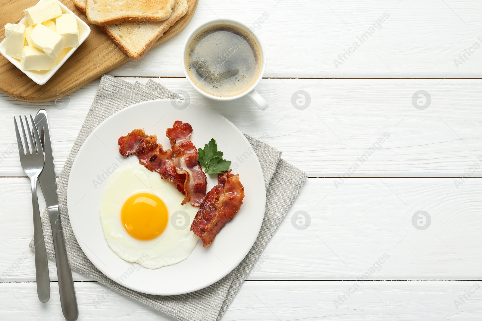 Photo of Delicious breakfast with sunny side up egg served on white wooden table, flat lay. Space for text