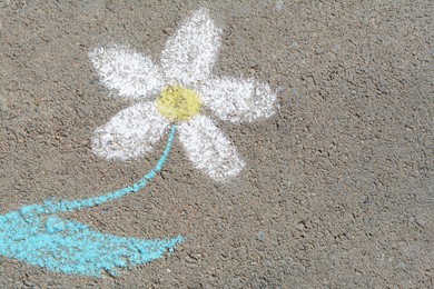 Photo of Flower drawn with colorful chalks on asphalt outdoors, top view. Space for text