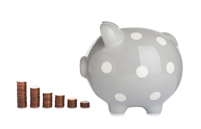 Photo of Ceramic piggy bank and many coins on white background