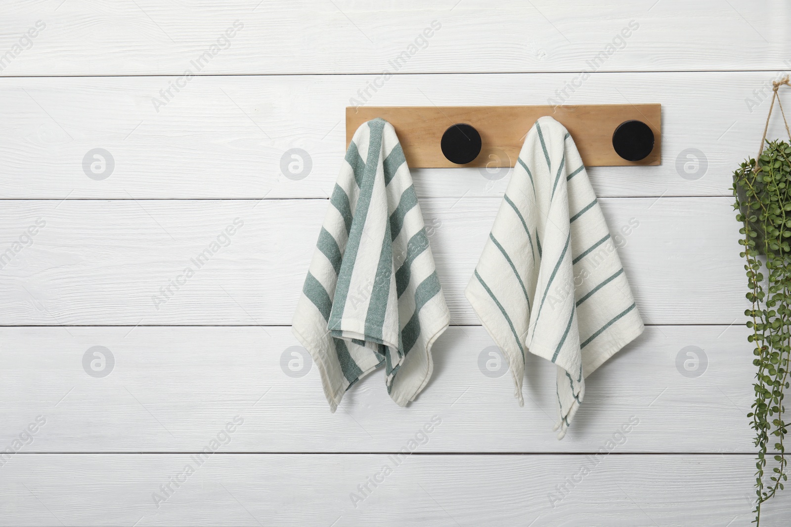 Photo of Different clean kitchen towels hanging on rack