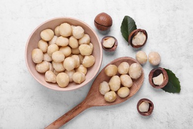 Photo of Delicious organic Macadamia nuts on light gray table, flat lay