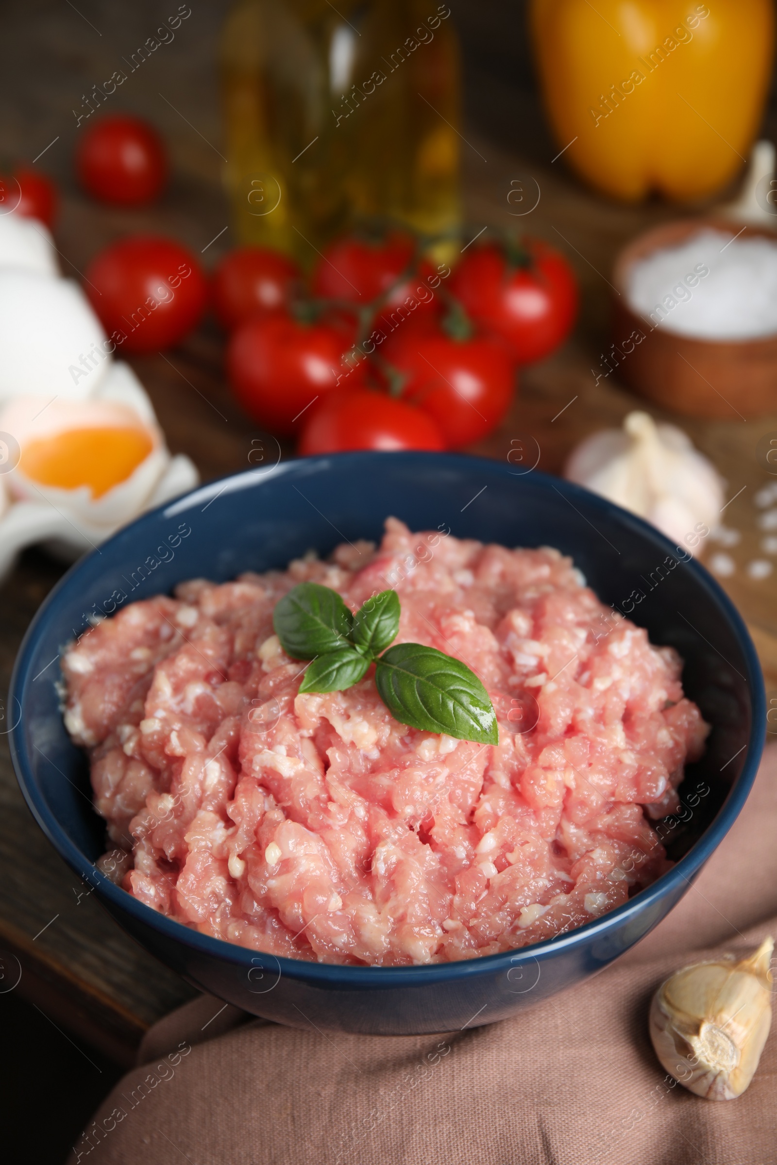 Photo of Raw chicken minced meat with basil and ingredients on table