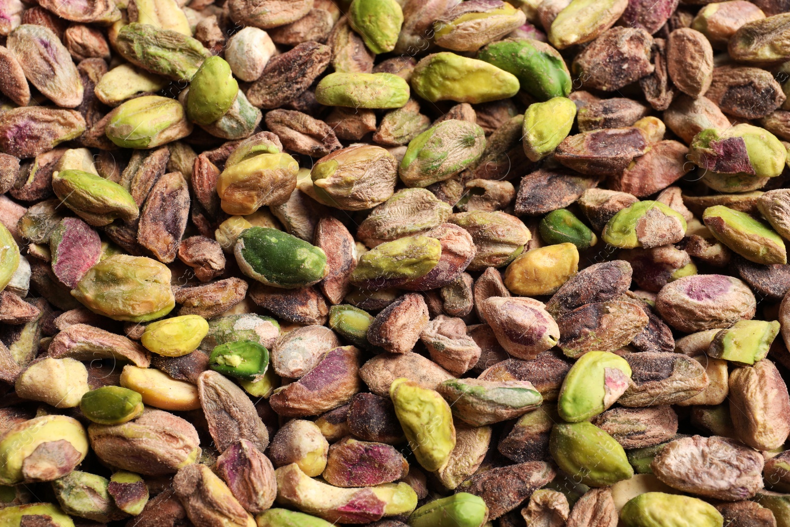 Photo of Shelled organic pistachio nuts as background, top view