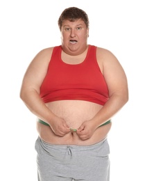 Photo of Emotional overweight man measuring waist with tape on white background