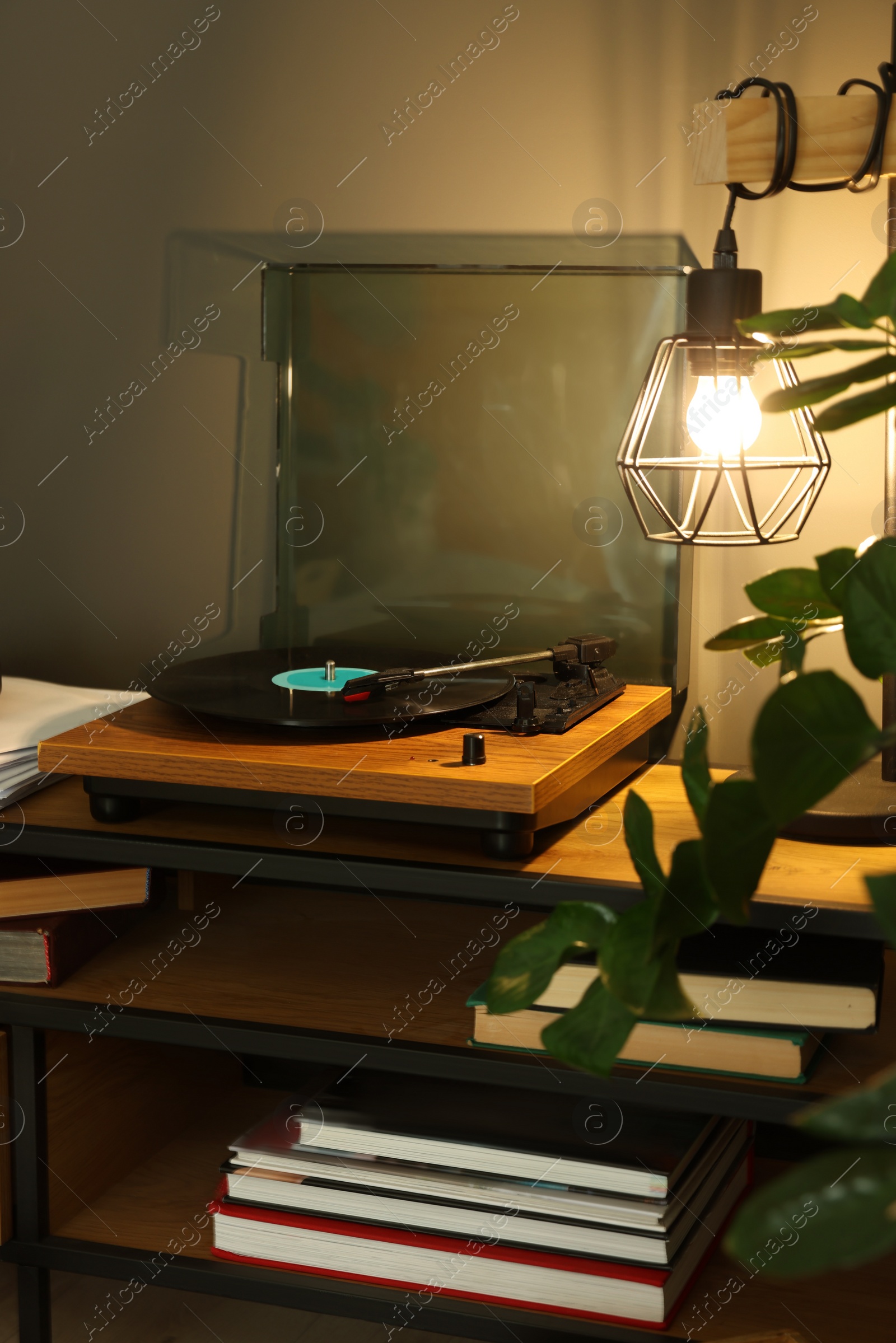 Photo of Stylish turntable with vinyl record on table indoors