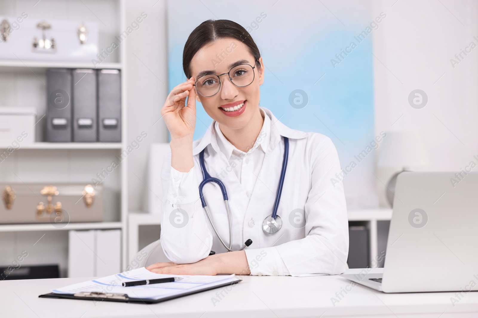 Photo of Medical consultant with stethoscope at table in clinic