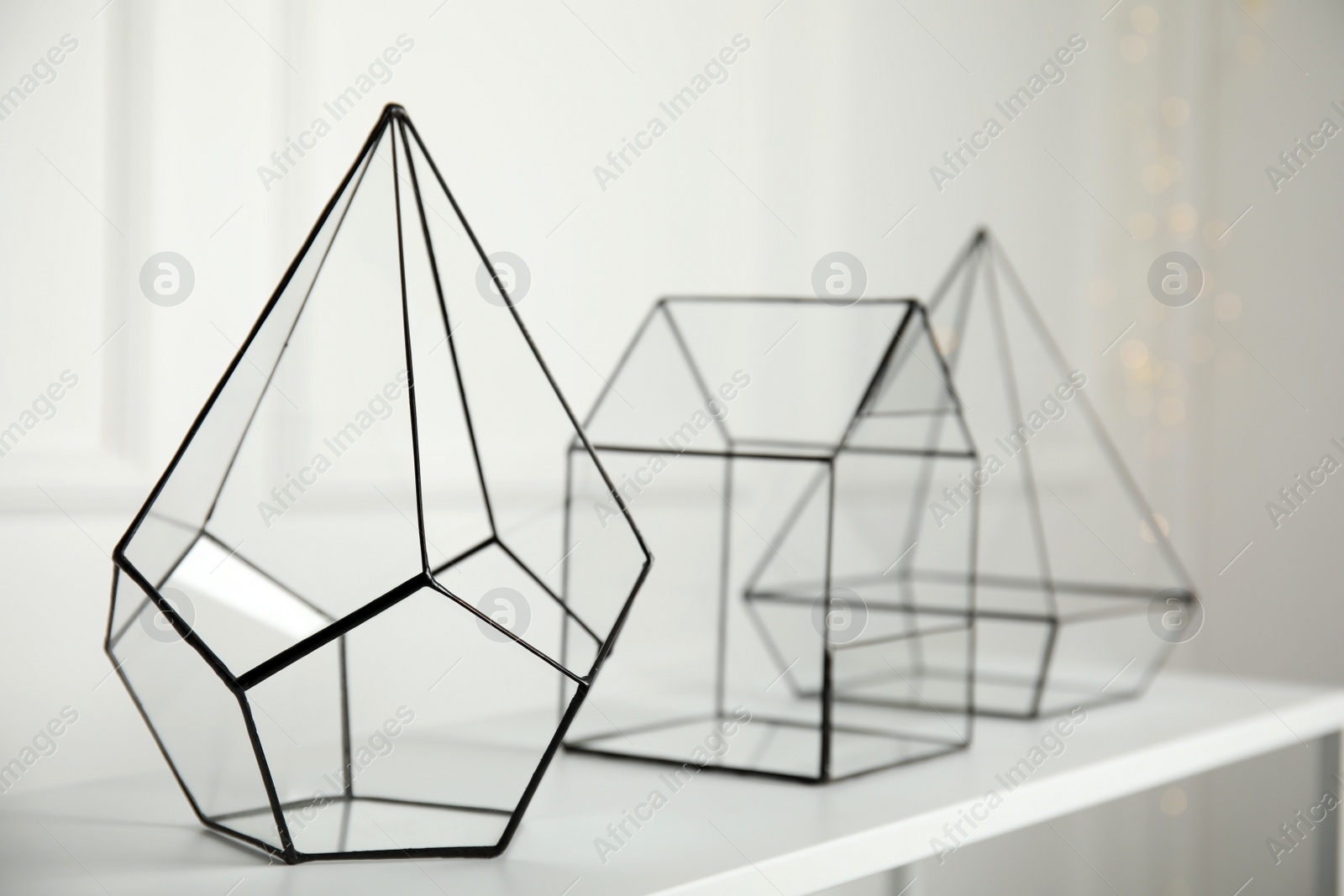 Photo of Empty glass florarium vases on white table indoors