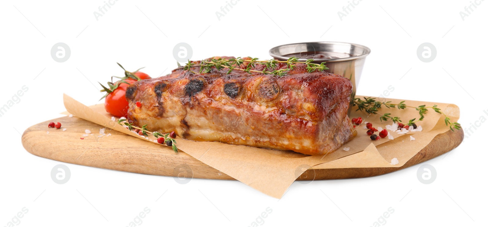 Photo of Tasty roasted pork ribs, thyme, sauce and tomatoes isolated on white