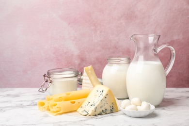 Photo of Fresh dairy products on table against color background