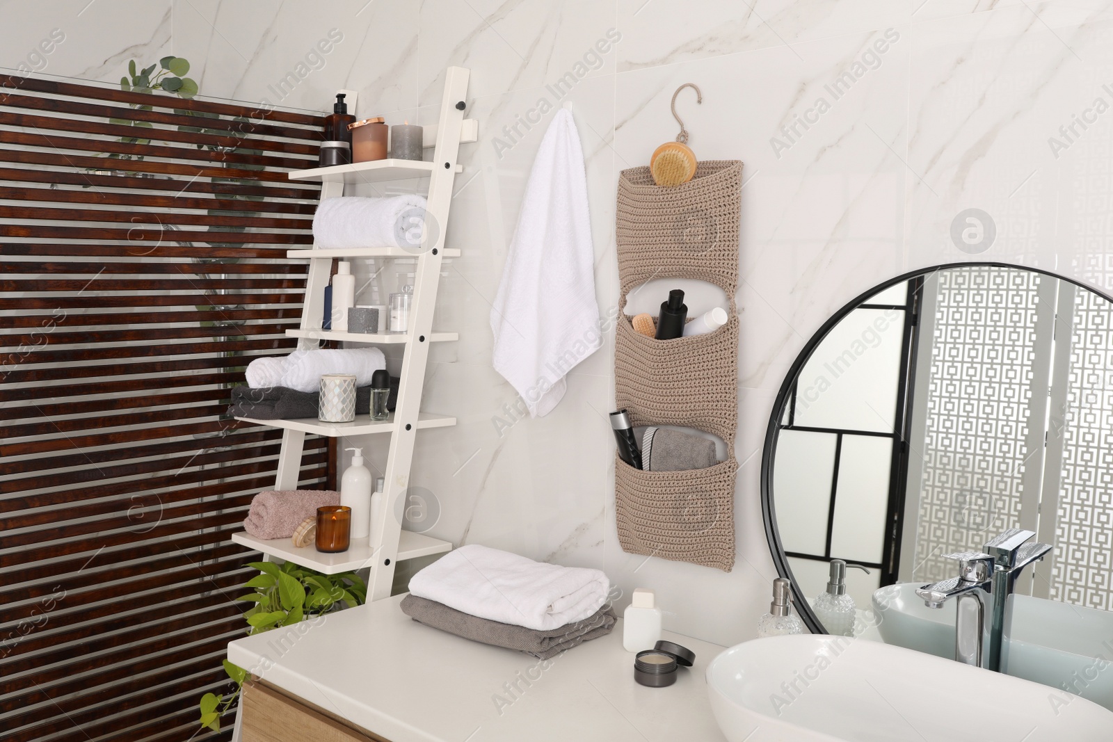 Photo of Knitted organizer hanging on wall in bathroom